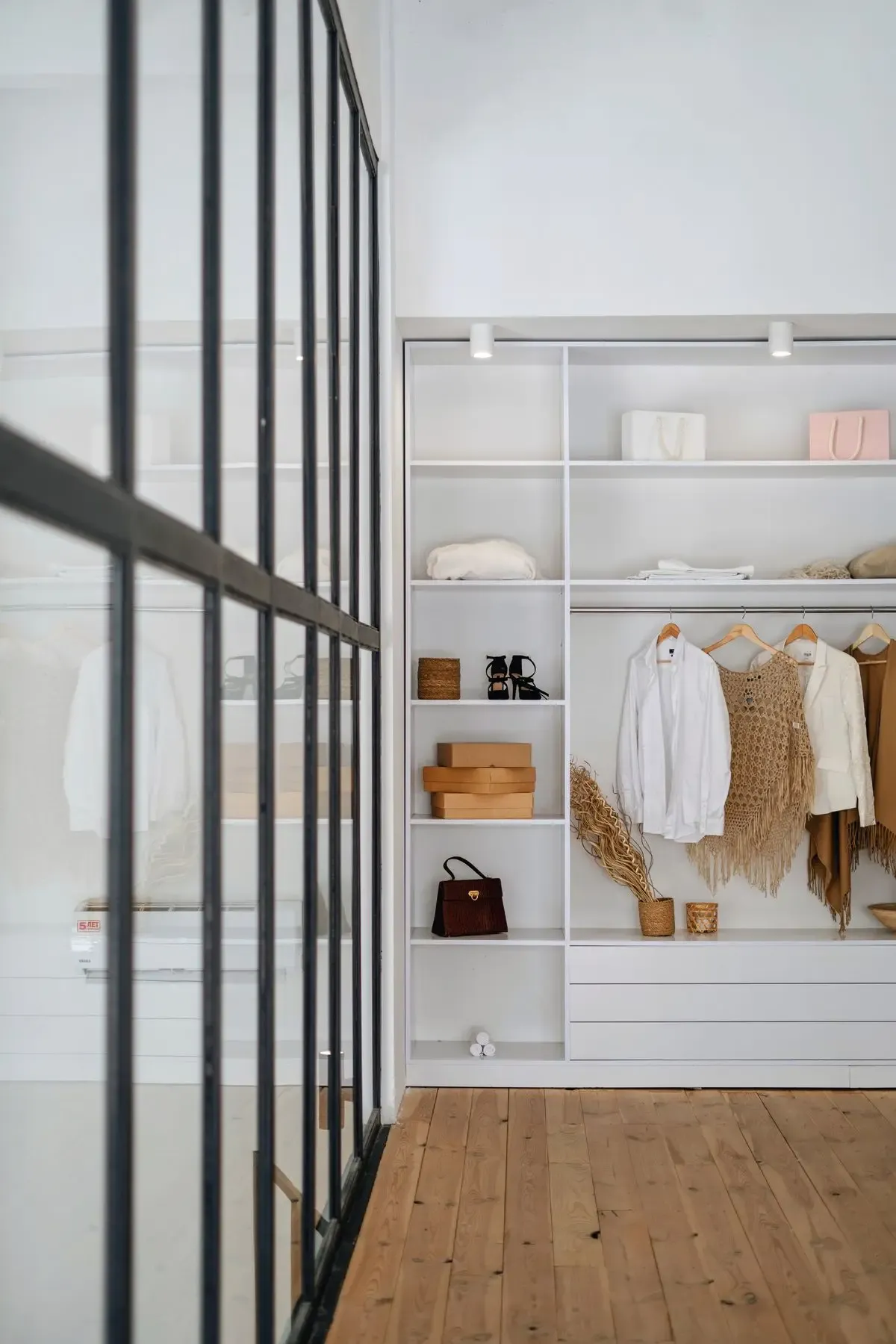An organized wardrobe with clothing, shoes, handbags, and storage boxes.