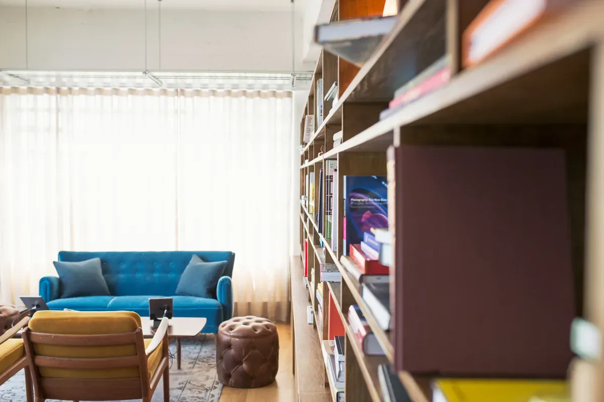 Bookshelves, a blue sofa, chairs, and a coffee table in a sunlit room.